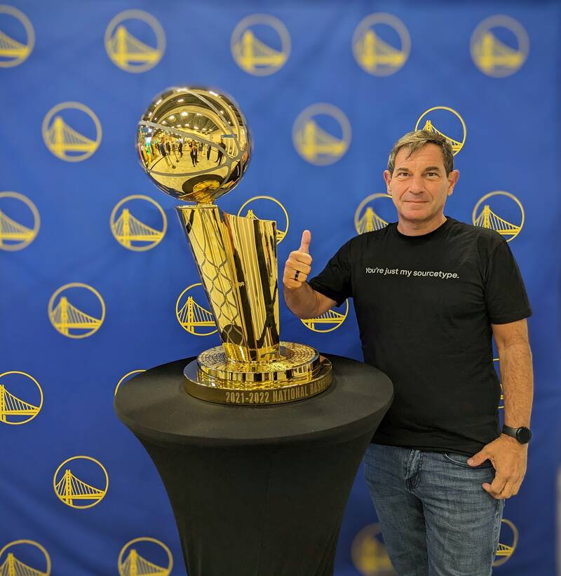 Christopher Alghini beside the NBA Championship trophy.