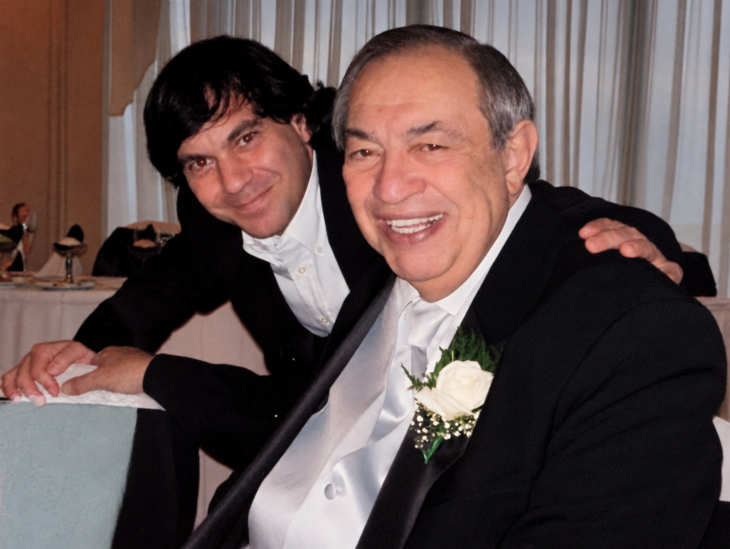 Christopher Alghini, left, with his father Ronald Anthony Alghini Sr., seated together in formal attire.
