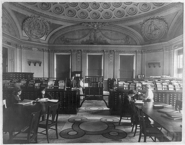 Readers examining books and albums in the Library of Congress Prints Division reading room.